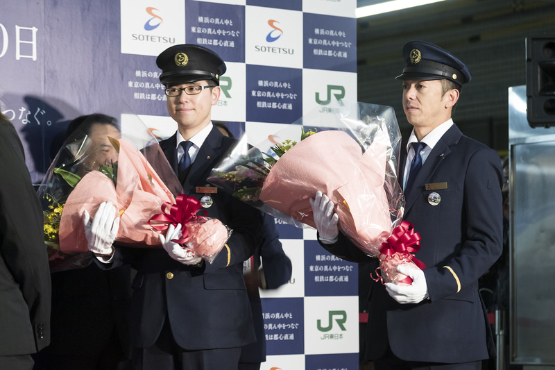 1番列車を担当する指導運転士 馬場貴史氏、車掌 戸井田信宏氏に花束が贈呈された
