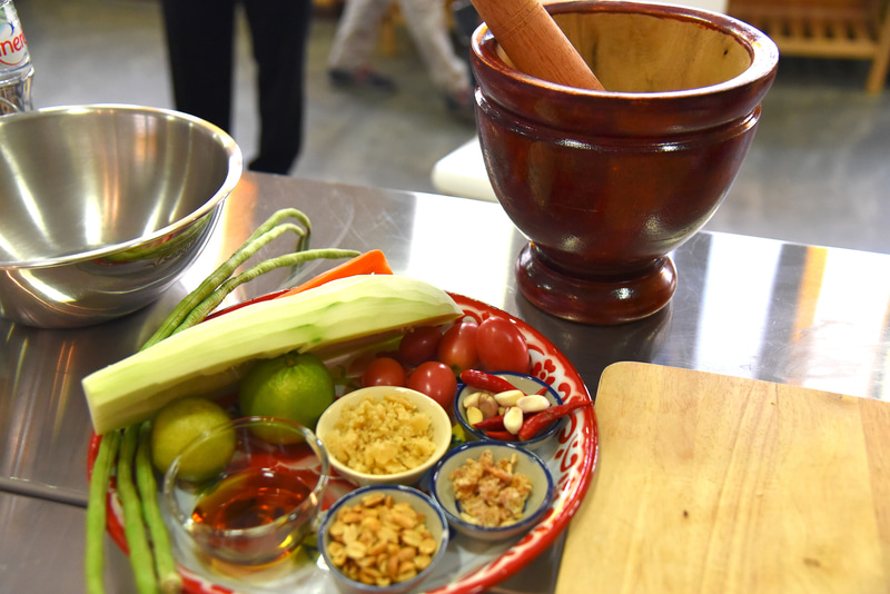 グリーンパパイヤを細切りし、クロックで調味料と一緒に叩き混ぜる