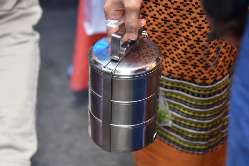 お寺にて「タンブン」に向かう人々の手にはピントが握られていた