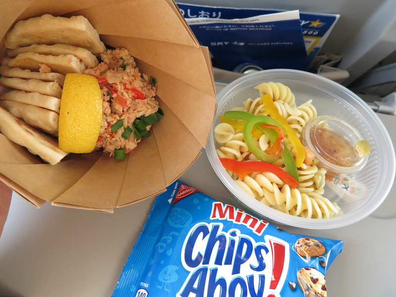 サイパン発の復路の機内食はチャモロ料理風。左から、チキンケラグエン ティティヤス添え、パスタサラダとチョコチップクッキー。意外と辛い！