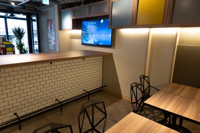 カウンターの左手にラウンジスペースがある。ラウンジの奥でエレベーターとつながっている