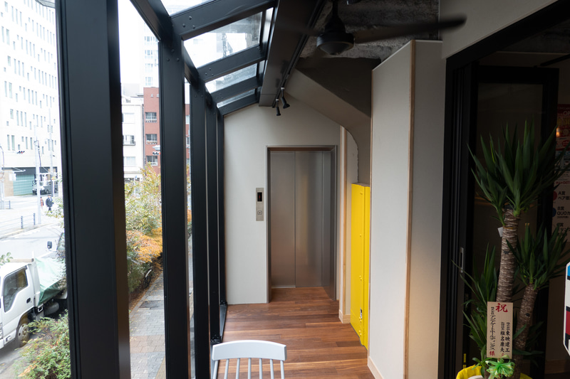 カウンターの左手にラウンジスペースがある。ラウンジの奥でエレベーターとつながっている