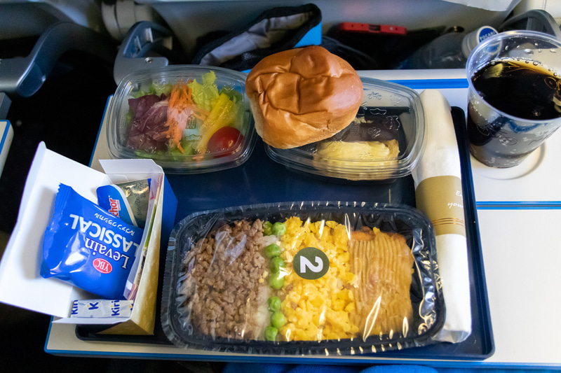 離陸して1時間30分後に1回目の機内食が提供される。サーモンがメインの三色丼をチョイスした