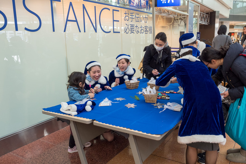 ANAブルーサンタとともにメッセージカードに願いごとを記入してクリスマスツリーに飾り付け