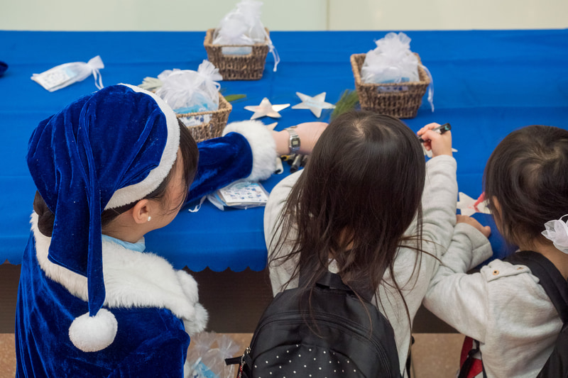 ANAブルーサンタとともにメッセージカードに願いごとを記入してクリスマスツリーに飾り付け