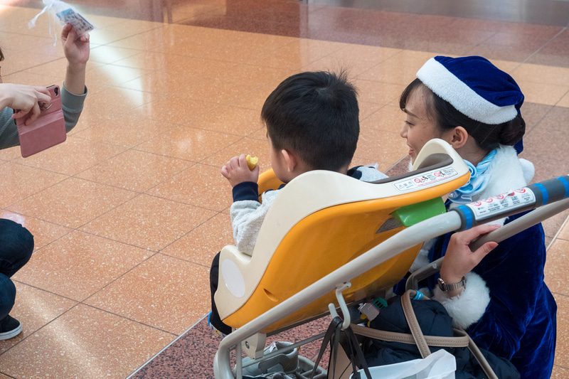 空港利用者にクリスマスプレゼント。ステッカーやクリスマスタグ、チョコレートをプレゼントした