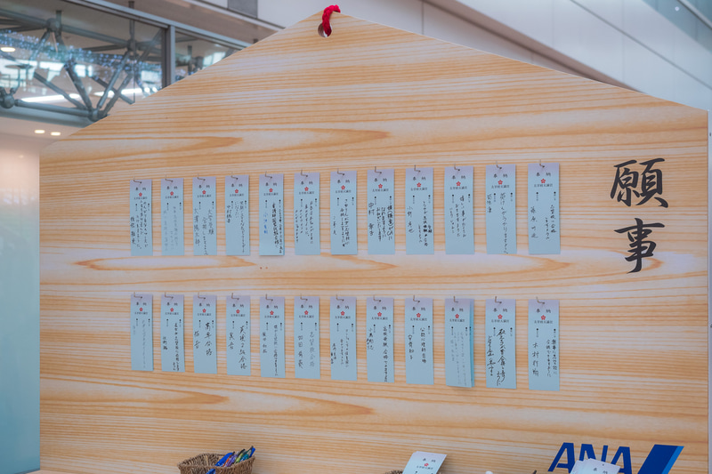 用意された願い札に願いごとを記入して特大絵馬に掛けられる