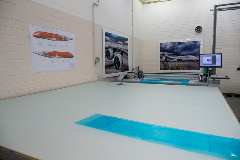 塗装工場内。ステンシルを制作する部屋には、初号機がロールアウトした際に使われたANAの旗が飾られていた