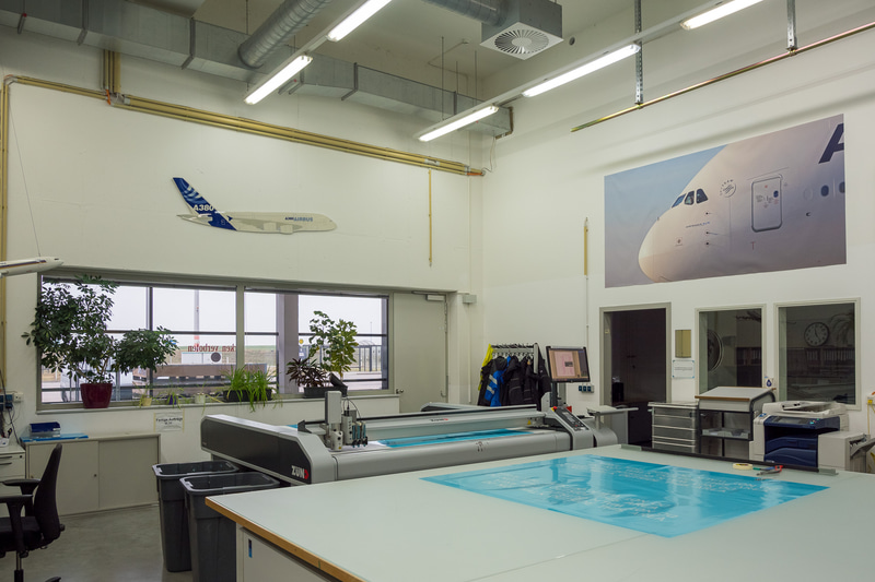 塗装工場内。ステンシルを制作する部屋には、初号機がロールアウトした際に使われたANAの旗が飾られていた