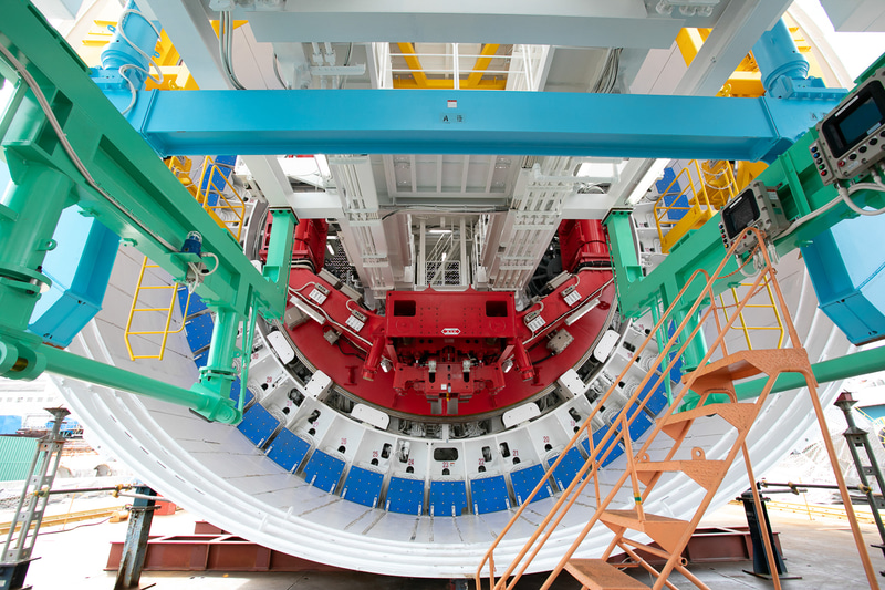 シールド内に送り込まれたセグメントは、エレクター（赤い部分）のフックに固定される（写真提供：JR東海）