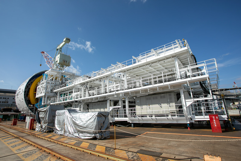 シールドマシン後方にはセグメントを送り出す装置のほか、（泥土圧シールドマシンのため）掘削した高圧の土砂の圧力を弱めながら排出するスクリューコンベアなどの設備が続く（写真提供：JR東海）