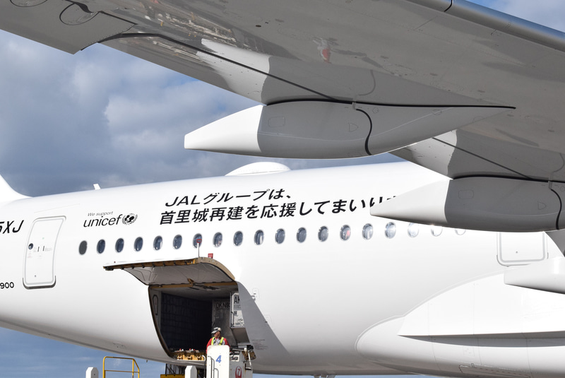 機体後方に「JALグループは、首里城再建を応援してまいります。」のメッセージが描かれている