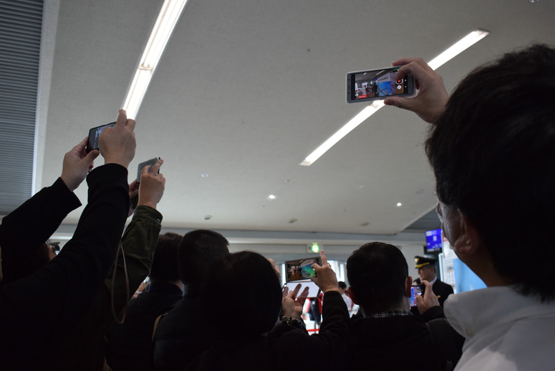 機長を写真に収めようと多くの搭乗客がスマホを向ける。映画スターのようだ