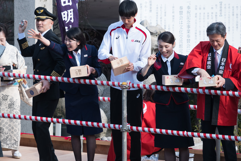 特設ステージからの豆まき。多くの人が列を成して福を受け止めていた