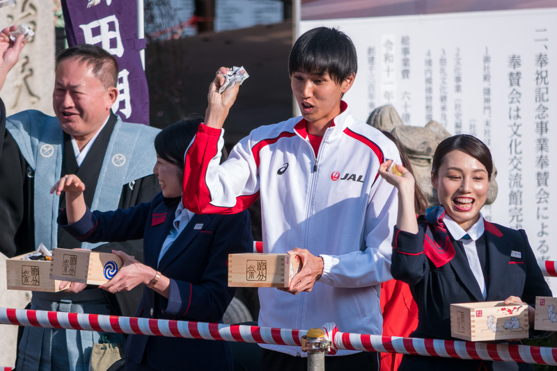 特設ステージからの豆まき。多くの人が列を成して福を受け止めていた