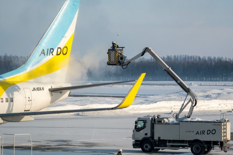 氷点下の駐機場ではチャーター便で使用する機材への防除雪氷作業が進められていた