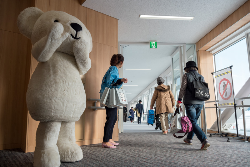 株式会社AIRDO 代表取締役社長 草野晋氏（左上）らが記念品を配布するとともに搭乗客をお見送り