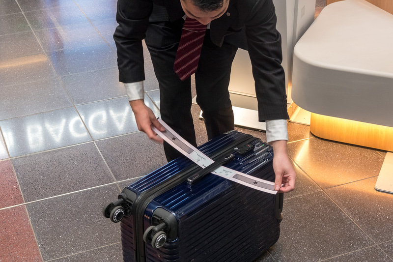 自動チェックイン機でのタグ発行から自動手荷物預け機への流れを、日本航空株式会社 空港企画部 旅客・制度企画グループ 主任 槇裕作氏がデモ。具体的な手順は後述する