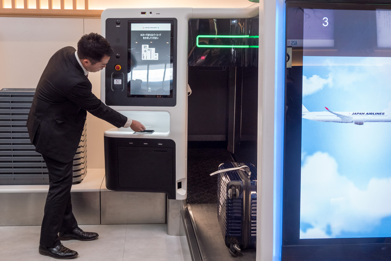 自動チェックイン機でのタグ発行から自動手荷物預け機への流れを、日本航空株式会社 空港企画部 旅客・制度企画グループ 主任 槇裕作氏がデモ。具体的な手順は後述する
