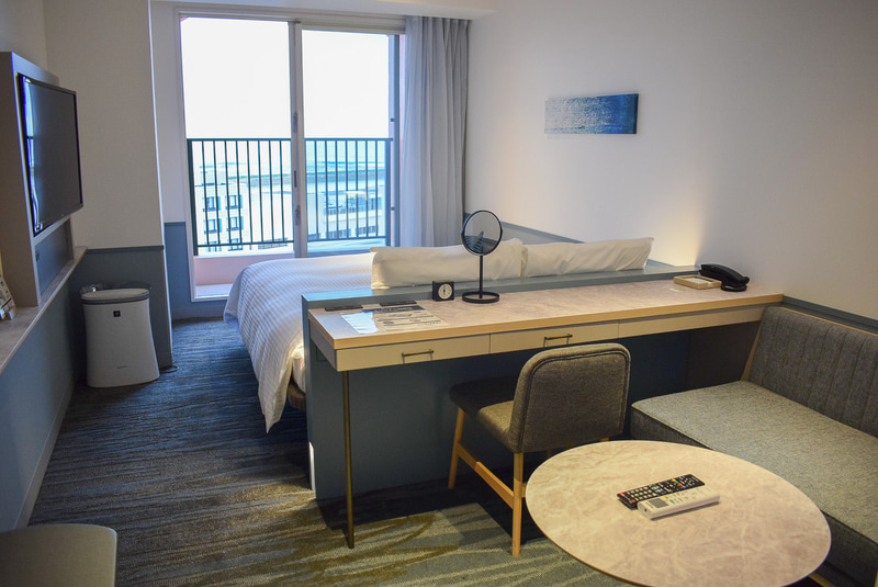 オーシャンビューダブル。幅180cmのダブルベッドが海の見える窓に向かって設置されている