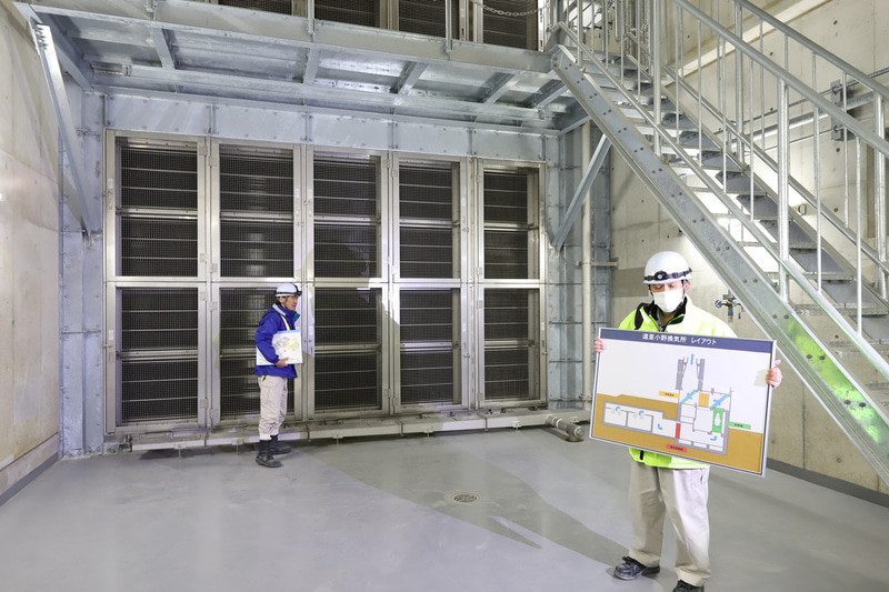 電気集じん機の説明。職員が持っている説明板の赤い部分にあたる。遠里小野換気所はこれを4基設置している