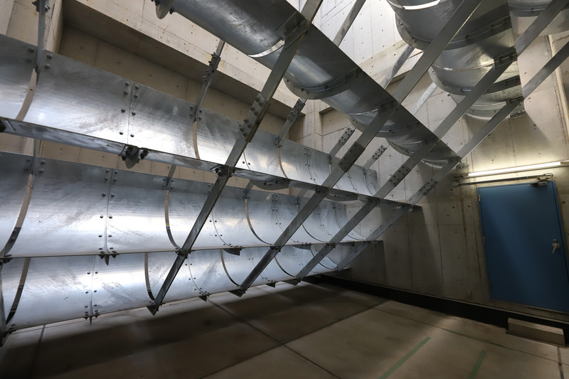 消音装置を通った空気は再び垂直方向に曲げられ、そのまま建物の上部から大気に放出される