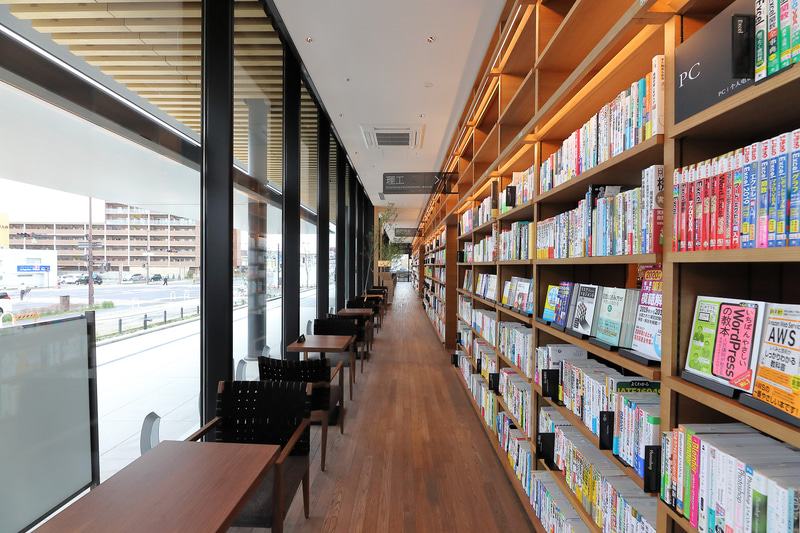 店内の数か所にテーブルとチェアを設置、購入前の本を持ってゆったりと過ごせる。「本とコーヒーをお楽しみください」というプレートまで設置している