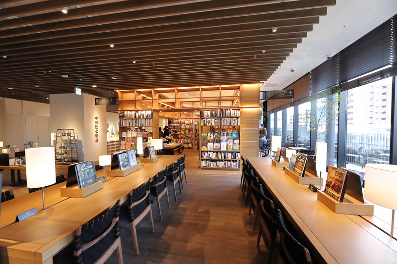 店内の数か所にテーブルとチェアを設置、購入前の本を持ってゆったりと過ごせる。「本とコーヒーをお楽しみください」というプレートまで設置している