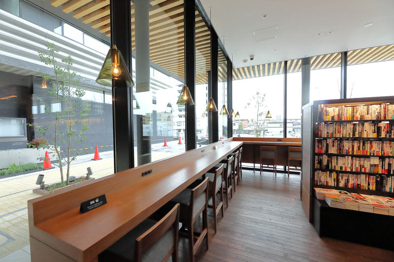 店内の数か所にテーブルとチェアを設置、購入前の本を持ってゆったりと過ごせる。「本とコーヒーをお楽しみください」というプレートまで設置している