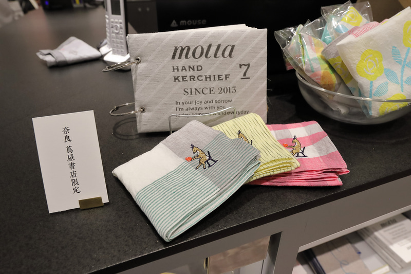 ブックカバーやハンカチにはイニシャルなどの刺繍を入れることも。チェアに座って本を読む鹿の刺繍も奈良 蔦屋書店限定