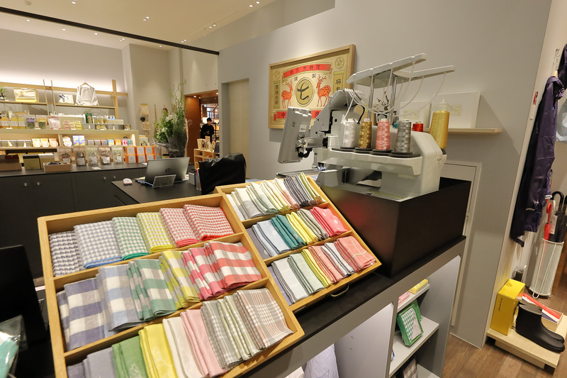 ブックカバーやハンカチにはイニシャルなどの刺繍を入れることも。チェアに座って本を読む鹿の刺繍も奈良 蔦屋書店限定