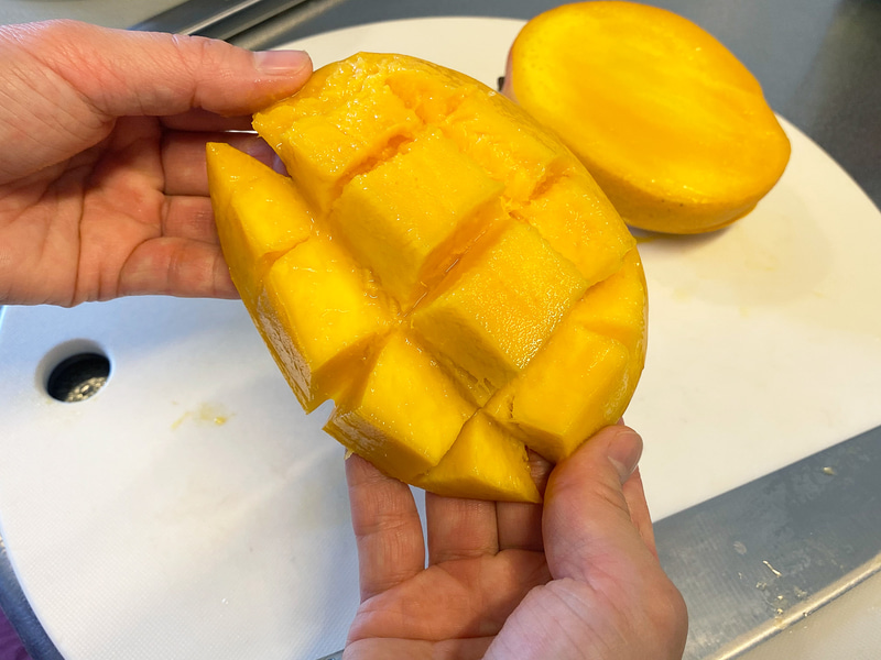 サイの目に切り込みを入れて、皮の裏側から押すように反らせます