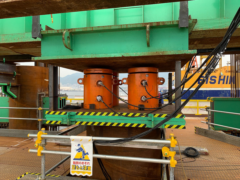 静的載荷試験機。写真右のオレンジの円柱が、1万kN対応の油圧ジャッキで、これを4基使用して荷重をかける