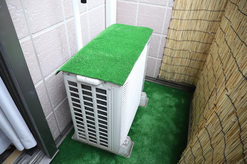 余った人工芝はエアコン室外機に被せた。室外機天板に直射日光が当たらないだけで夏場の冷房効率が上がる