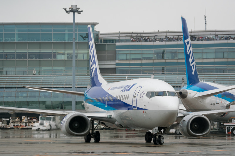 駐機場に向かうスーパードルフィンを出迎えるために横断幕を持ってスタッフが待機