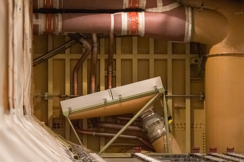 機体下部の貨物室奥（通常は壁になっており見ることはできない）に搭載しているHEPAフィルター。このダクトはマニホールドになっており、機外からの空気と、HEPAフィルターを通過した機内からの循環空気を混合し、中央の太いダクトで機体上部へと運んでいる。