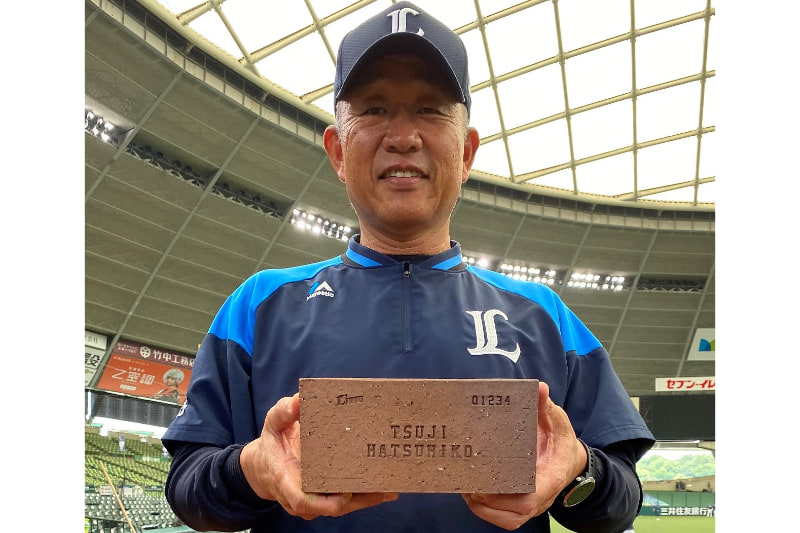 自身の刻印レンガのサンプルを手にした辻監督