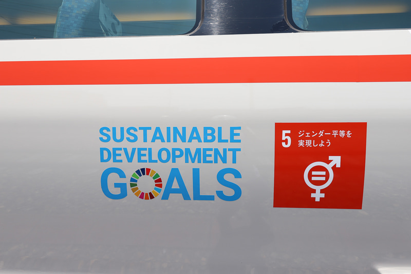 SDGsの目標の1つ「ジェンダー平等を実現しよう」のアイコンと、イメージカラーである“RED ORANGE”のリボン