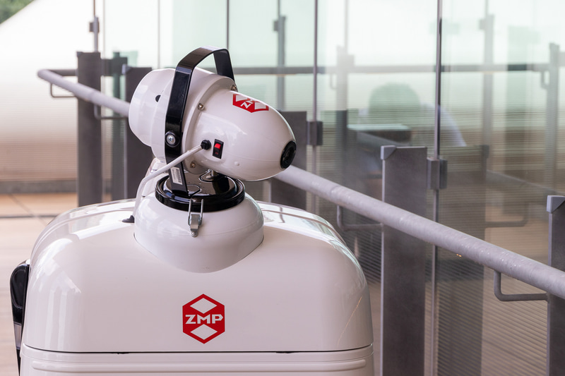PATORO（パトロ）。開発元はZMP。パトロールと消毒作業を行なう自律移動型ロボット。複数のカメラを搭載するほか、コミュニケーション用として表情を変えられる大型ディスプレイを前面に搭載している