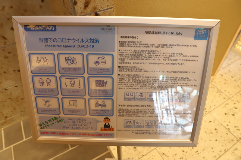 ロビーのコロナ対策の表示板。足元にはディスタンスを保つ目印もあった
