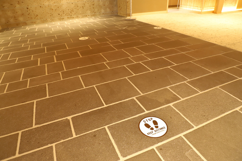 ロビーのコロナ対策の表示板。足元にはディスタンスを保つ目印もあった