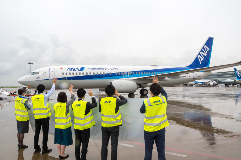 出発するNH747便を約35名のスタッフが横断幕とともにお見送り。同便は88名（幼児1名含む）を乗せ、8時54分に出発。9時3分にC滑走路から離陸し能登空港（のと里山空港）へ向かった