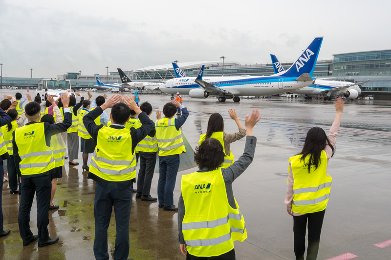 出発するNH747便を約35名のスタッフが横断幕とともにお見送り。同便は88名（幼児1名含む）を乗せ、8時54分に出発。9時3分にC滑走路から離陸し能登空港（のと里山空港）へ向かった