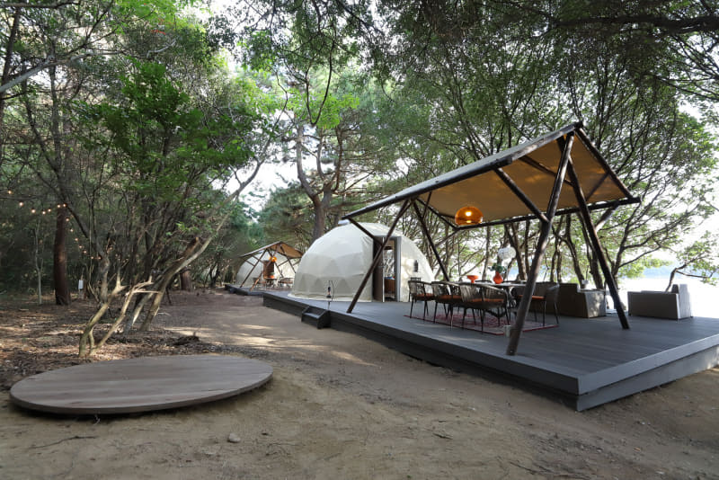 デッキと大きなタープで天候に関係なくグランピングが楽しめそう