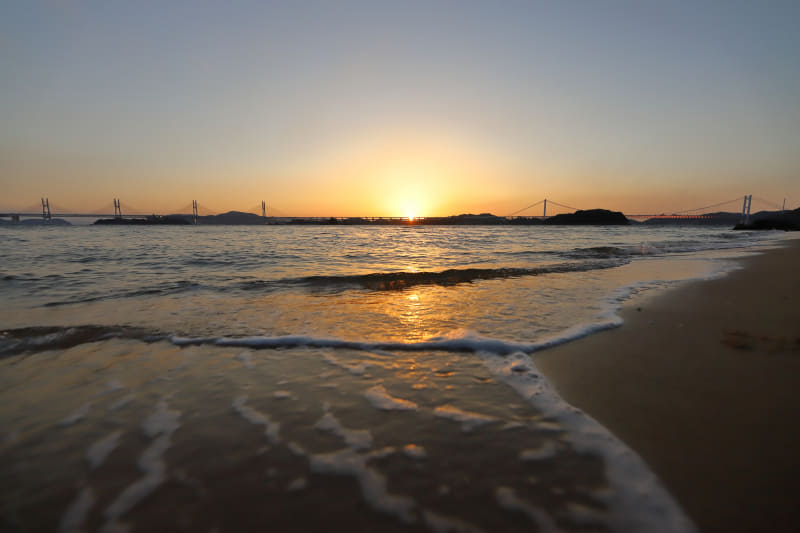 瀬戸内に沈む夕日をしばし鑑賞。波打ち際で14mmの広角レンズで撮影してみた