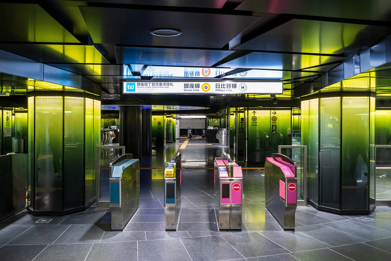 銀座線改札口。ラインカラーとなるレモンイエローの光柱で彩られる。天井まわりの改修により頭上高は2.1mから2.2～2.3m程度にアップしている。