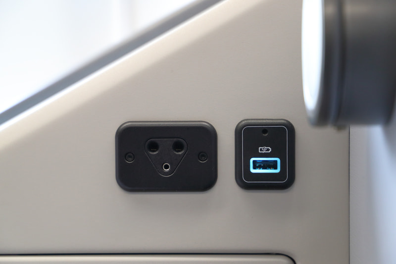 充電可能なUSBポートは小物入れの上部とシート下部の2か所。110Vのコンセントはシート下部にあり日本で使われているプラグも使用可能。画面の操作はタッチパネルのほかスマホのようなコントローラで操作ができ、こちらも日本語に対応する