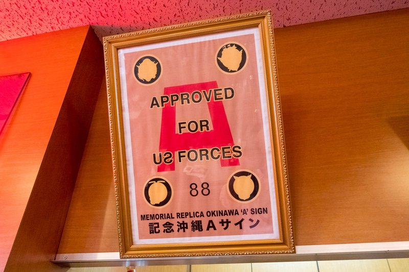 店内はアメリカンなデザイン。米統治時代の米軍による営業許可証「Aサイン」のレプリカ（写真左）も掲示されている