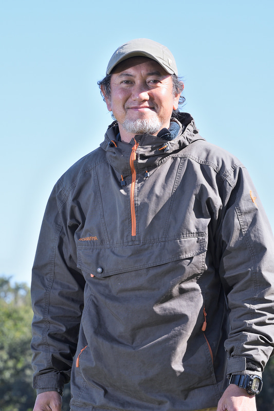 アウトドアコーディネーターの小雀陣二（こすずめじゅんじ）さん。雑誌への寄稿、イベント出演などでアウトドアの楽しさを伝える活動を行なう。海、川、山など場所を選ばず、焚き火料理、ワンバーナーの山料理、ダッチオーブンなどを使ったキャンプ料理を作り出す。執筆著書多数。クルマへのキャンプ道具の積み下ろし経験は数え切れない