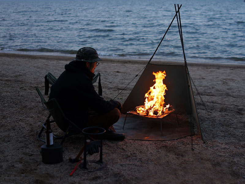 風から焚き火を守る